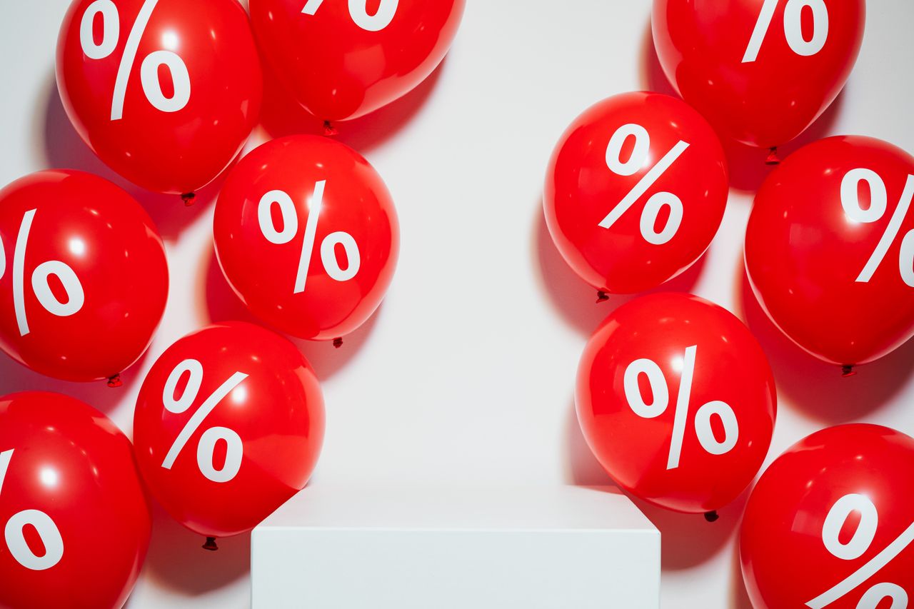 Red balloons with percentage signs, ideal for marketing promotions and sales events.
